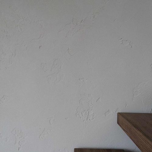 Kambarys su šviesiais atspalviais ir dekoratyvine sienų apdaila